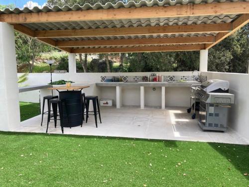 a patio with a table and chairs under a pergola at Les jardins de Funtanone T1 in Vignale