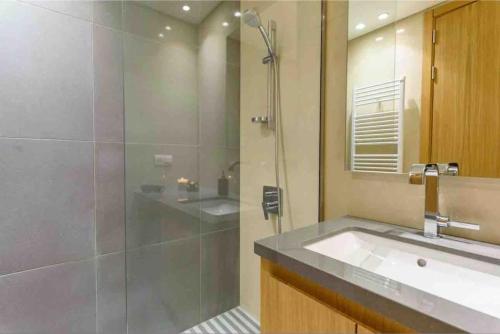 a bathroom with a glass shower and a sink at Luxurious Saifi 477, 2-BR Apt in Beirut