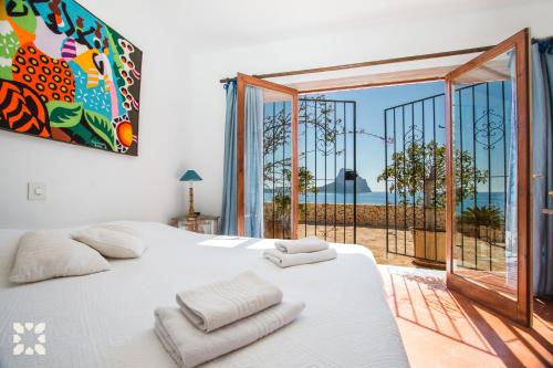 um quarto com uma cama branca e vista para o oceano em Villa Timeris by Abahana Villas em Calpe