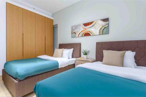 two beds in a hotel room with blue and white at Luxurious Saifi 477, 2-BR Apt in Beirut