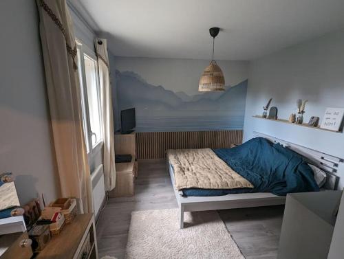 una camera da letto con un letto con un piumone blu di Jolie maison au pied du Vercors a Bourg-de-Péage