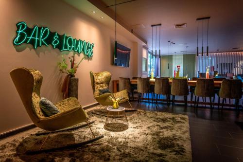 a bar and lounge with chairs and a table at Friendly Cityhotel Oktopus in Siegburg