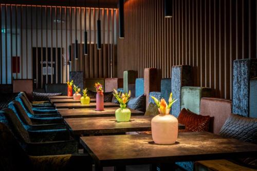 a row of tables with vases of flowers on them at Friendly Cityhotel Oktopus in Siegburg
