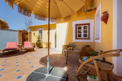 a patio with an umbrella on a house at Casa da Moura in Lagos