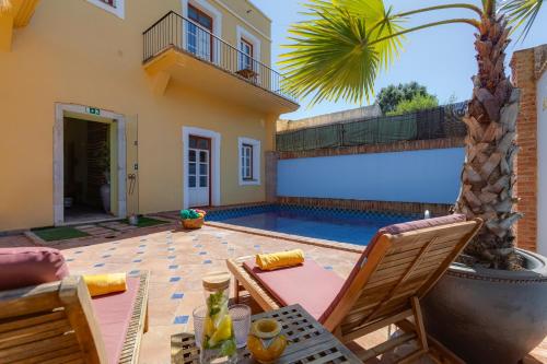 a patio with a table and chairs and a swimming pool at Casa da Moura in Lagos