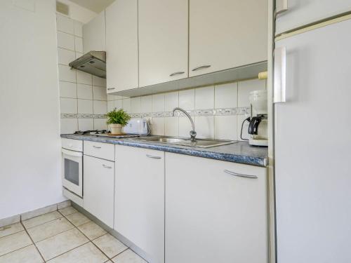 eine weiße Küche mit weißen Schränken und einem Waschbecken in der Unterkunft Apartment Muga-7 by Interhome in Empuriabrava