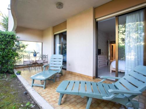 un patio avec deux chaises bleues et une table dans l'établissement Apartment Marines de Villeneuve by Interhome, à Villeneuve-Loubet