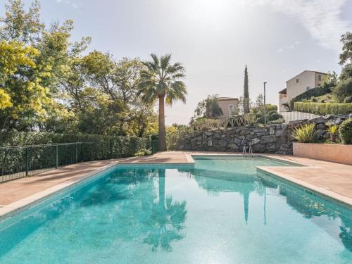 - une piscine dans une villa avec un palmier dans l'établissement Holiday Home Les Maisons du Golf-2 by Interhome, à Sainte-Maxime