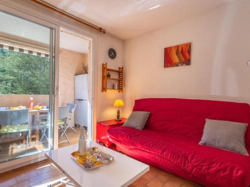 un canapé rouge dans un salon avec une fenêtre dans l'établissement Studio Hauts de la Madrague-13 by Interhome, à Saint-Cyr-sur-Mer
