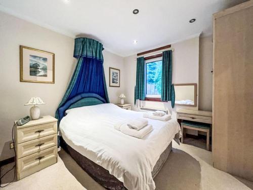 a bedroom with a large bed with blue curtains at Chalet Glen View by Interhome in Spean Bridge