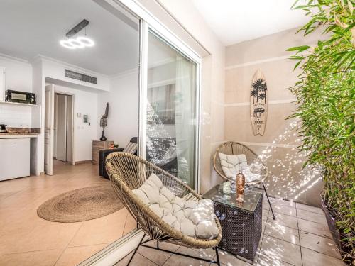 - un salon avec des chaises en osier et une table dans l'établissement Apartment Parc Pointe Croisette by Interhome, à Cannes