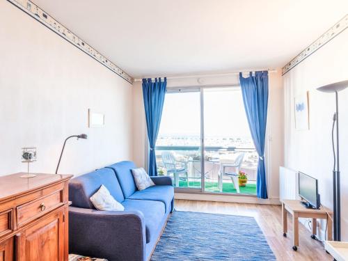 un salon avec un canapé bleu et une grande fenêtre dans l'établissement Studio Port Arcachon-9 by Interhome, à Arcachon