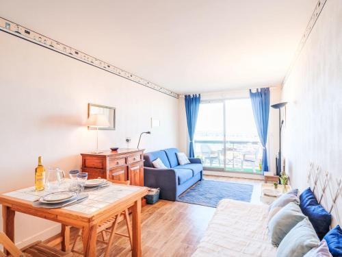 un salon avec une table et un canapé bleu dans l'établissement Studio Port Arcachon-9 by Interhome, à Arcachon