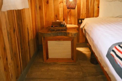 Un dormitorio con una cama y una mesita de noche al lado de una cama. en Puluong Luna Resort, en Pu Luong