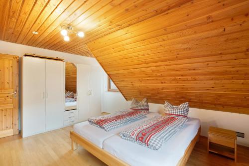- une chambre avec un lit et un plafond en bois dans l'établissement Wohnung Kuhblick, à Baiersbronn
