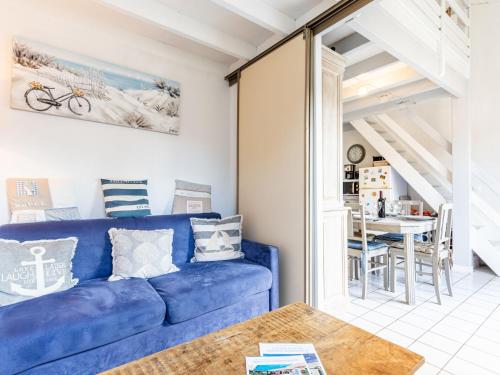 a living room with a blue couch and a table at Apartment Hameau de Talaris-17 by Interhome in Les Mathes