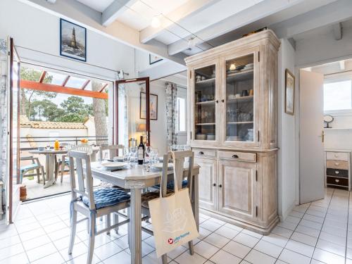une salle à manger avec une table, des chaises et une armoire dans l'établissement Apartment Hameau de Talaris-17 by Interhome, aux Mathes
