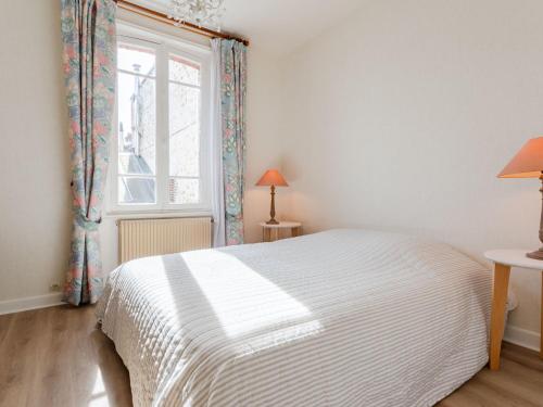 a bedroom with a white bed and a window at Holiday Home Gambetta by Interhome in Deauville