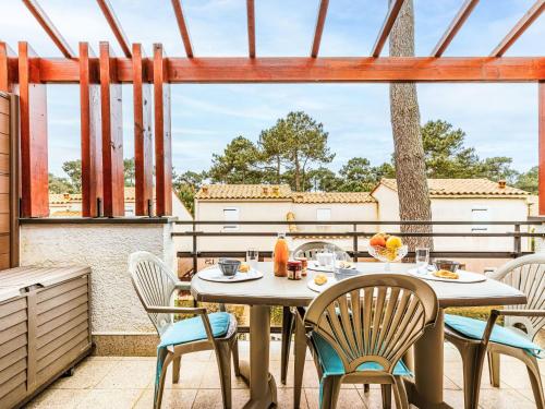 a patio with a table and chairs on a balcony at Apartment Hameau de Talaris-17 by Interhome in Les Mathes