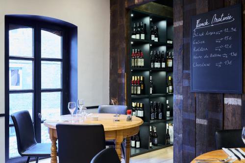 a dining room with a table and a shelf of wine bottles at Les Tanneurs in Namur