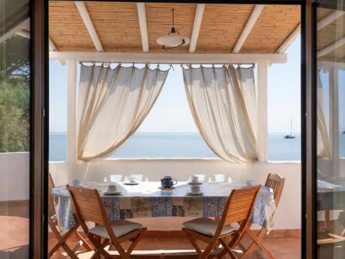 een eetkamer met een tafel en stoelen voor een raam bij Holiday Home 'Su Faru' estate-1 by Interhome in Pula