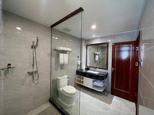 a bathroom with a shower and a toilet and a sink at Notis International Hotel 诺蒂斯国际酒店 in Phnom Penh