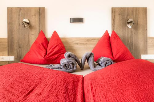 a bed with red pillows and a red blanket at Chalet Matzhof in Leogang