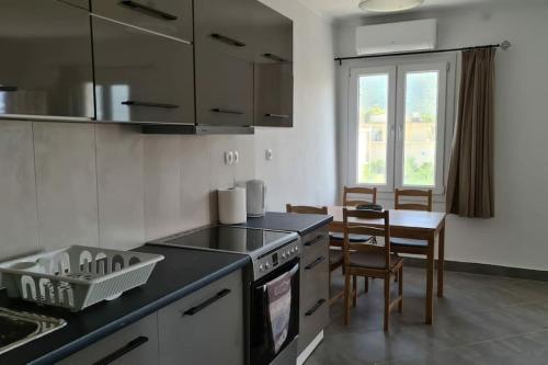 a kitchen with a stove and a table with chairs at Igoumenitsa Apartment in Igoumenitsa