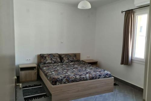 ein Schlafzimmer mit einem Bett in einem Zimmer mit einem Fenster in der Unterkunft Igoumenitsa Apartment in Igoumenitsa
