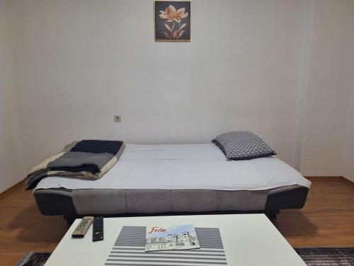 een bed in een kamer met een tafel en een schilderij aan de muur bij Apartman Vuković in Foča