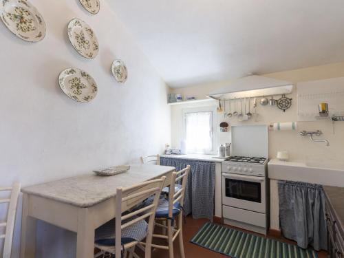 a kitchen with a table and a stove and plates on the wall at Holiday Home Casa Pinela Maria Sole by Interhome in Castellaro