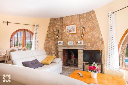 ein Wohnzimmer mit einer weißen Couch und einem Kamin in der Unterkunft Villa Teresa by Abahana Villas in Calpe