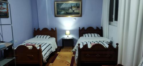 two beds in a room with blue walls at LEVI Apartment in Pogradec