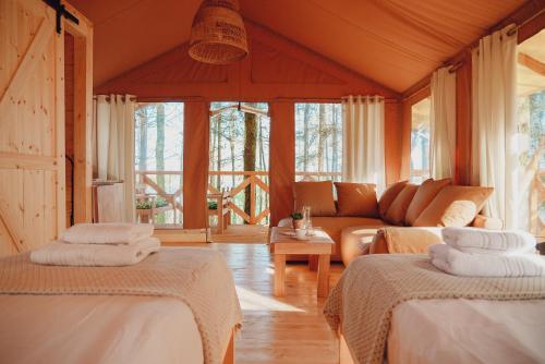 a living room with two beds and a couch at Glamping Mazury - Przystań Jeziorany in Jeziorany