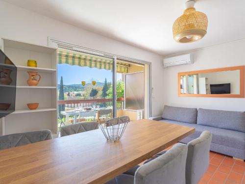 ein Wohnzimmer mit einem Tisch und einem Sofa in der Unterkunft Apartment Parcs du Lavandou-10 by Interhome in Le Lavandou