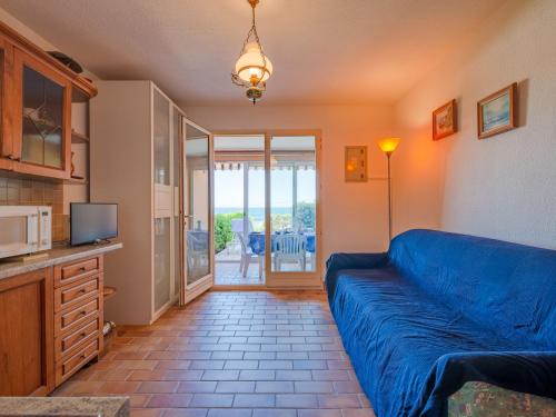 un salon avec un canapé bleu et une télévision dans l'établissement Apartment Le Front de Mer-6 by Interhome, à Saint-Aygulf