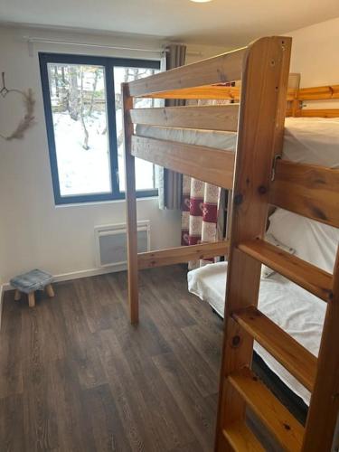 une chambre avec deux lits superposés et une fenêtre dans l'établissement chalet proche des pistes Ô chalet Dana, à Vars