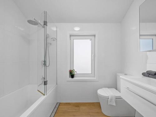 a white bathroom with a toilet and a window at 4 bdrms house ICC & Darling Harbour & central & CBD & China Town in Sydney