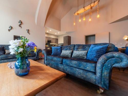 a living room with a blue couch and a table at Holiday Home Towan by Interhome in Newquay