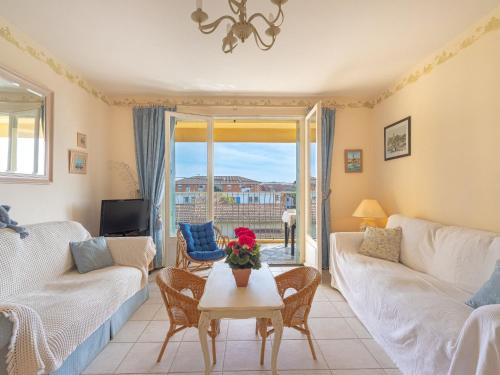 - un salon avec un canapé et une table fleurie dans l'établissement Apartment les voiles by Interhome, à Six-Fours-les-Plages