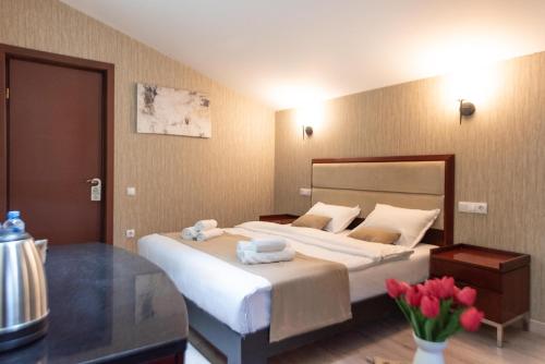 a bedroom with a large bed with towels on it at Kraveli Hotel in Tbilisi City