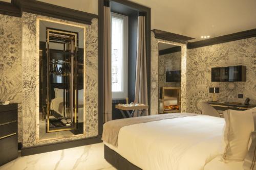 a bedroom with a large white bed and mirrors at Bra Hotel in Bari