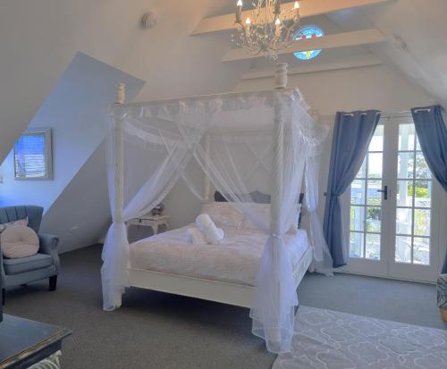 a bedroom with a canopy bed with a teddy bear on it at Bella Abode on Bribie - Loft with Pool in Bongaree