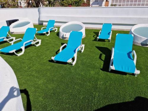 a group of blue chairs and tables on the grass at Gaviotas Beach Golf Love 11 in Almerimar