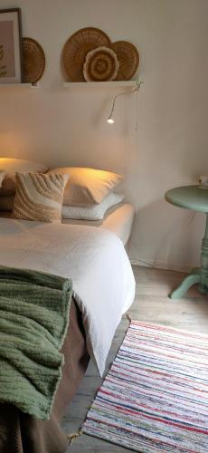 a bedroom with a bed and a table and a rug at "Les Chacobins" - appart'étape avec Garage Vélos in La Réole