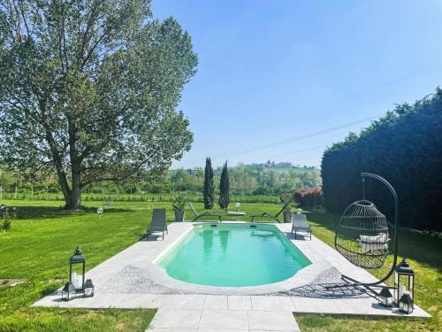 a swimming pool with two chairs and a gazebo at Apartment Viola by Interhome in CastellʼAlfero