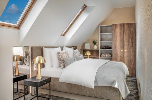 a bedroom with a white bed and two lamps at Hotel Maestro by Adrez in Prague