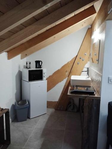 - une cuisine avec un four micro-ondes et une cuisinière dans l'établissement LE COCON l'unique expérience Cinéma room de la Grange Savoyarde 1km du Lac d'Annecy, à Lathuile