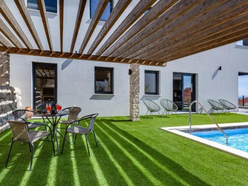 a patio with a table and chairs next to a swimming pool at Apartment Minimalist by Interhome in Šibenik