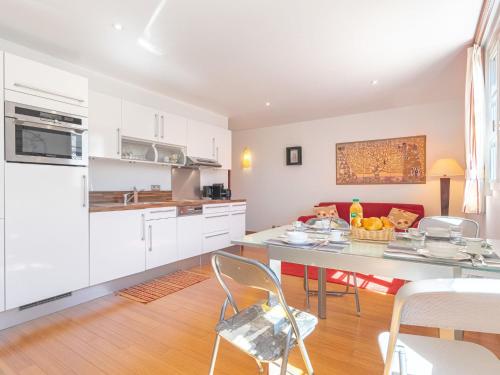 une cuisine avec des armoires blanches et une table et des chaises dans l'établissement Apartment Boulevard Louis Blanc-2 by Interhome, à Saint-Tropez
